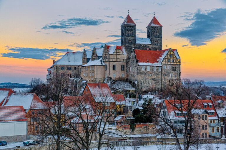 Das Quedlinburger Schloss und Stiftskirche im Winter beim Sonnenuntergang